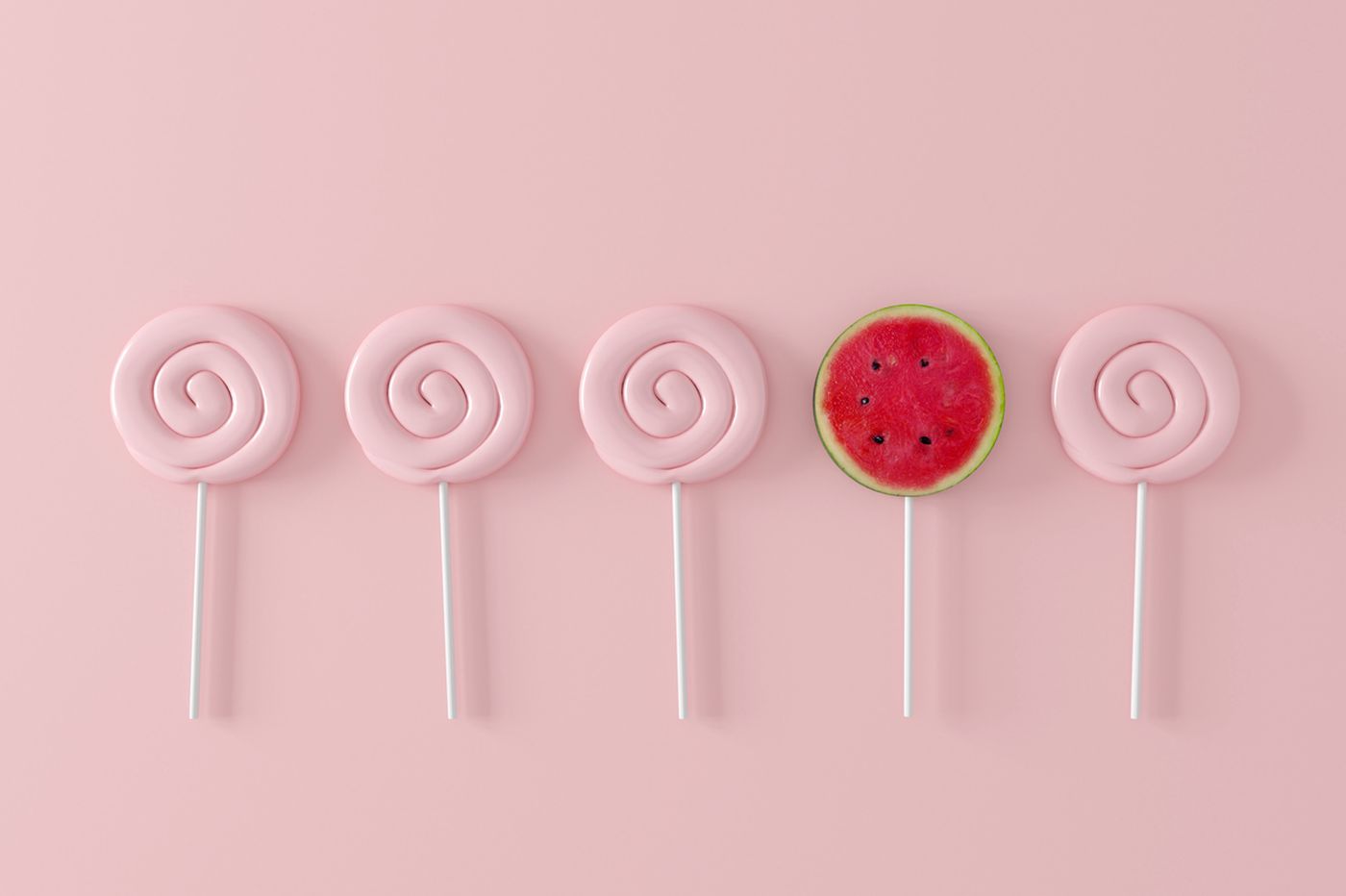 Watermelon candy on pastel pink background.