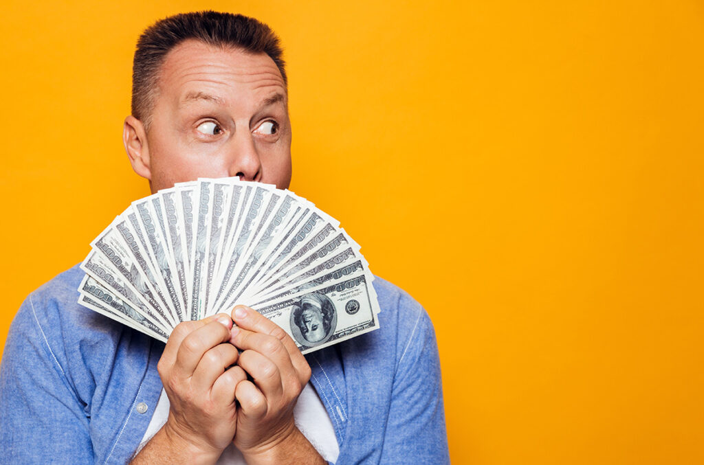 Portrait of a surprised man holding dollar bills