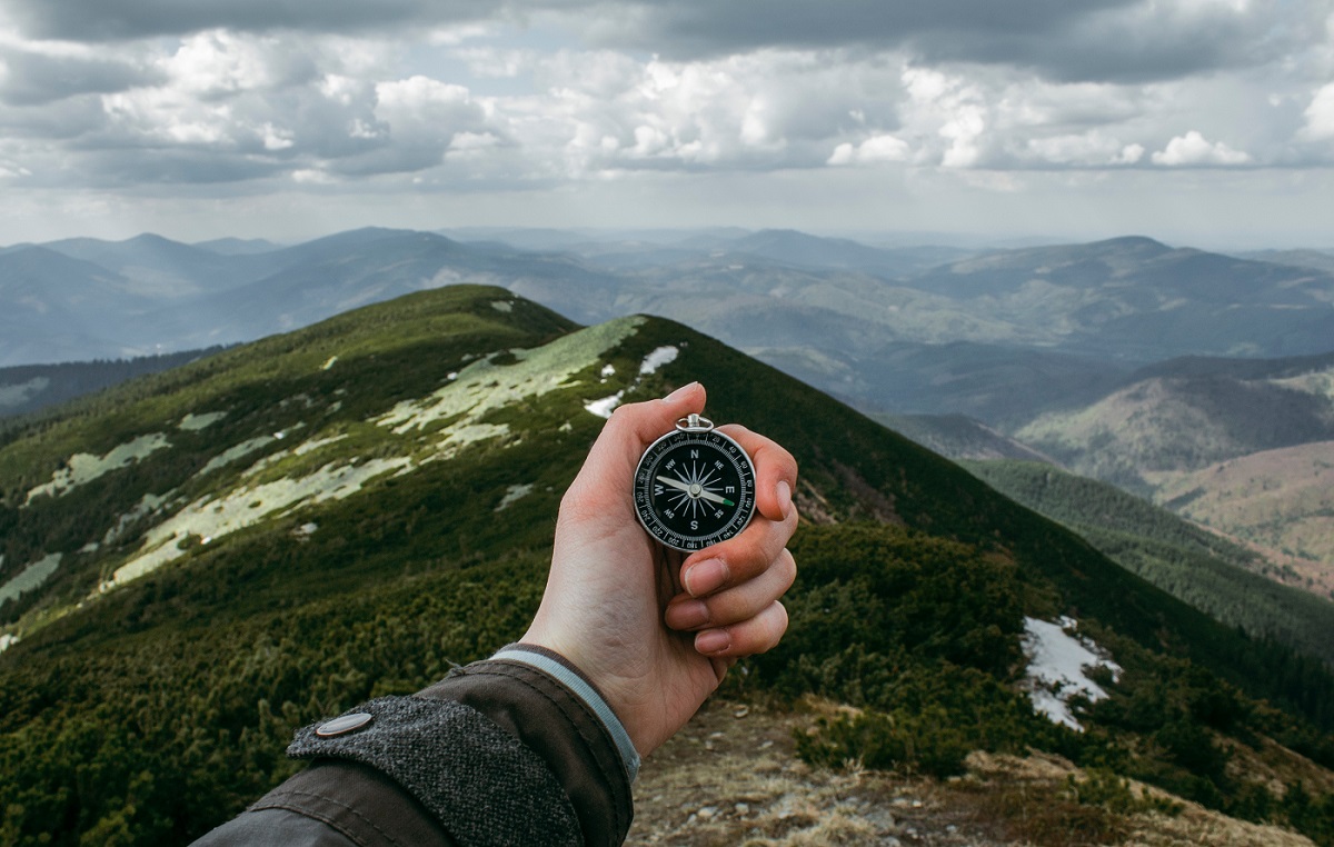 Man holding a compass on a mountain