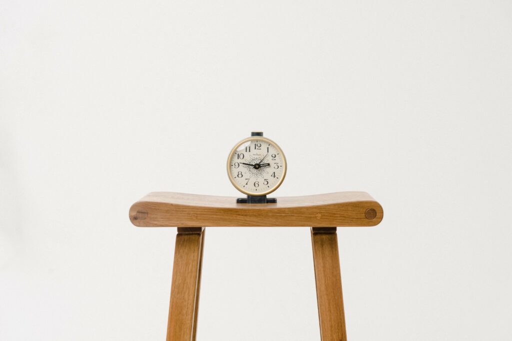 An alarm clock sitting on a stool