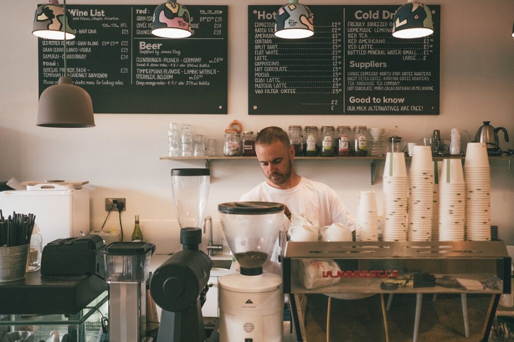 Photo of a barista making coffee in a café