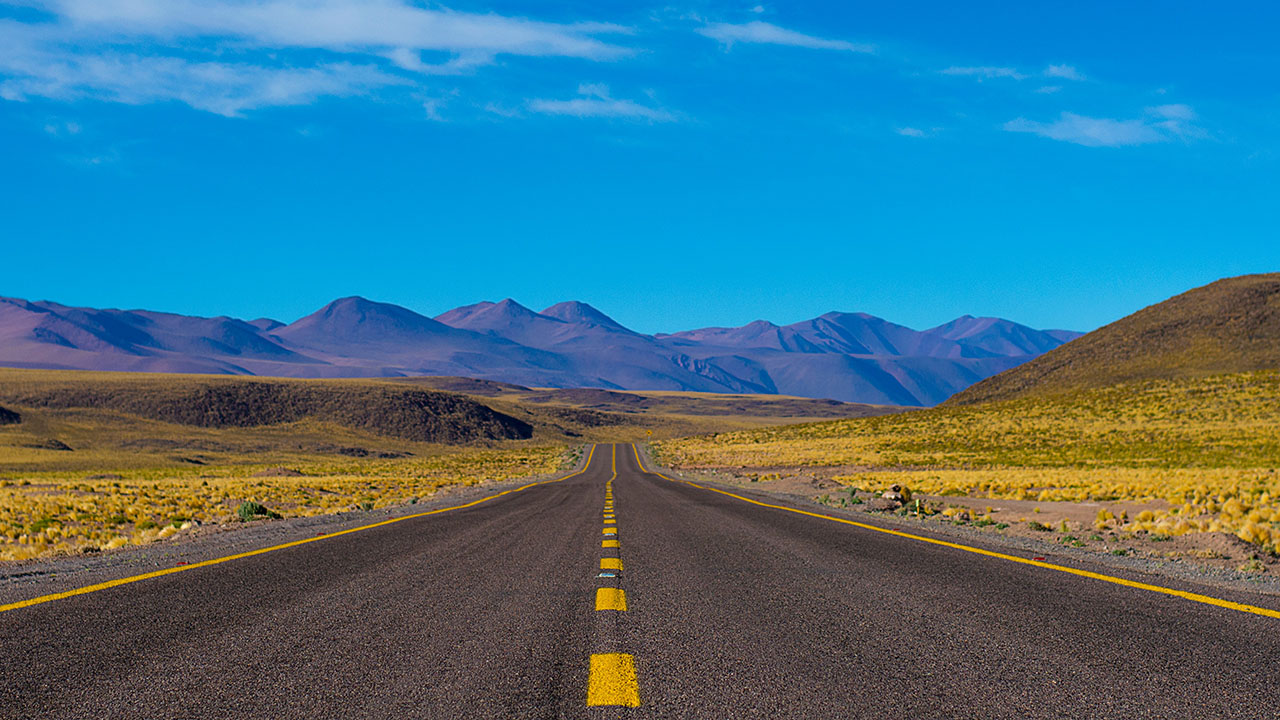 Empty paved road near mountains during daytime, ©Daniel Cartin / Unsplash