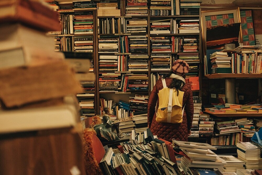 Photo of a girl looking around in a bookshop