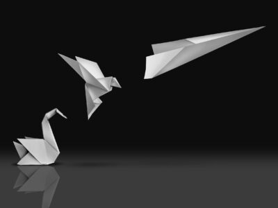 Picture of an origami swan transforming into a paper airplane evoking the concept of innovation and transformation