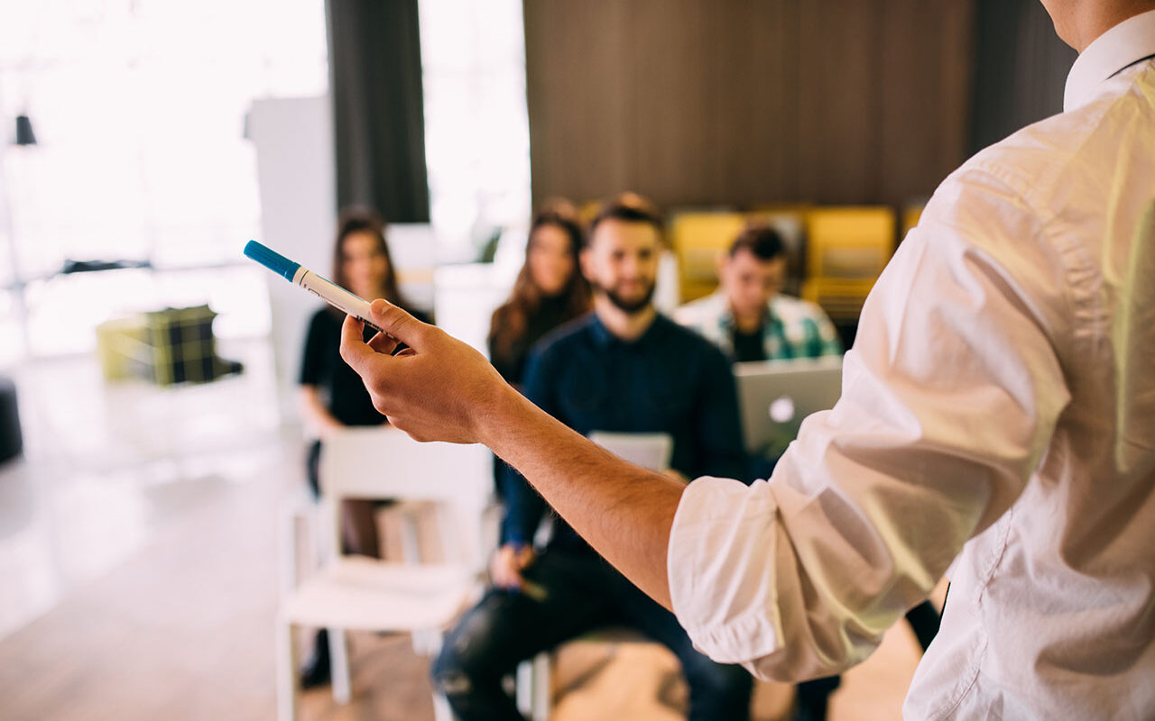 Lecture and training in business office for white collar colleagues. Focus on hands of speaker. ©F8studio / Adobe Stock