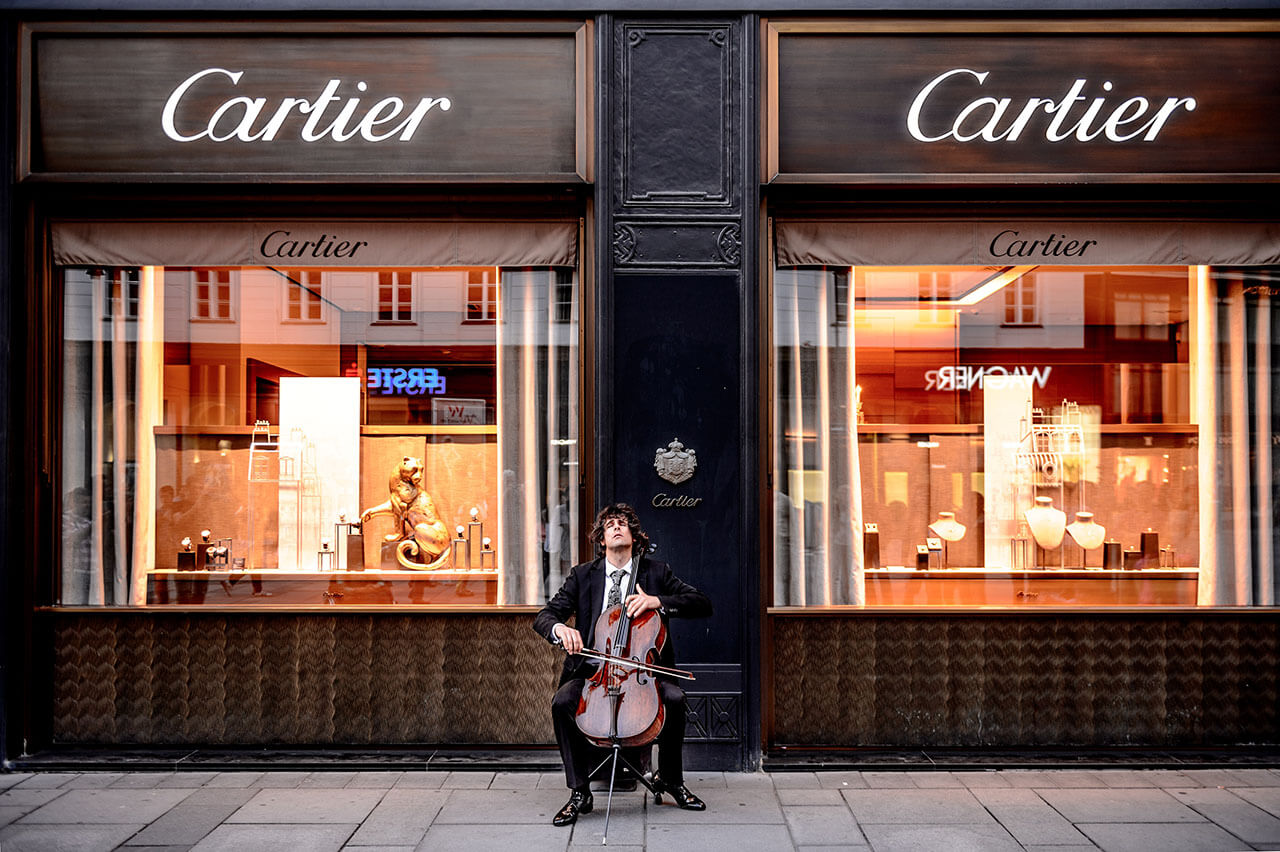 Man playing cello in front of store © Jacek Dylag / Unsplash