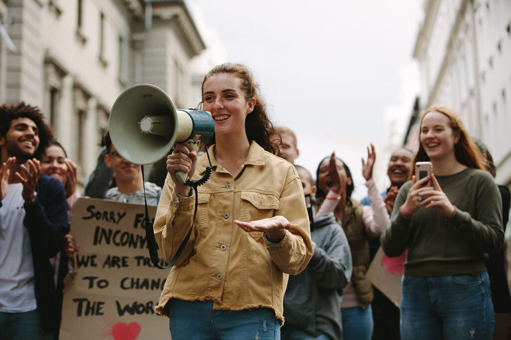 Woman with a megaphone in a rally, © Jacob Lund / Adobe stock