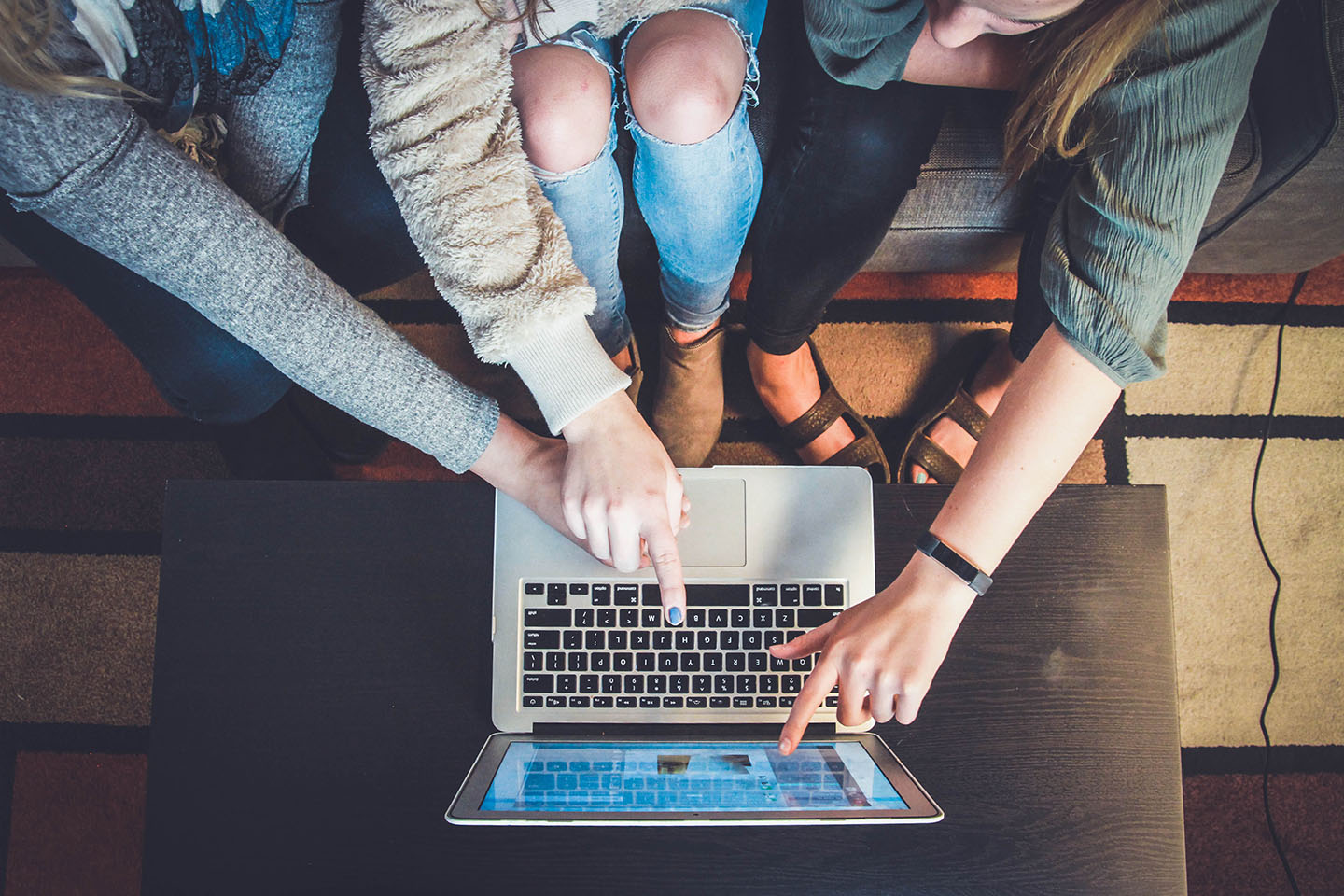 Three co-workers working together on the same screen. Feature photo by John Schnobrich on Unsplash.