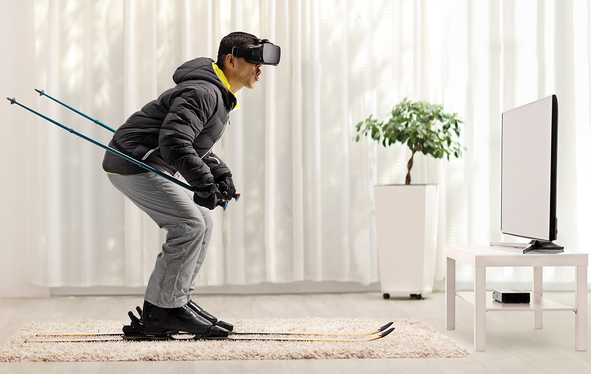 Man skiing with VR headset at home