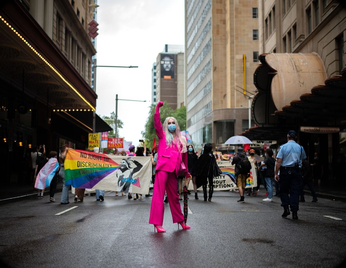 A photo of an LGBT+ activist holding their fist up at a protest representing leadership as a member of the LGBT+ community