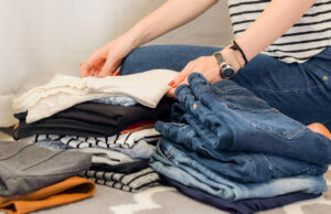 A woman folding her clothing.