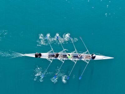 Photo of a rowing team rowing on the water.