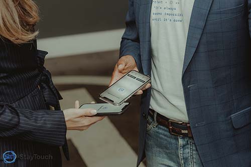 Photo of two people using the StayTouch app at a conference.
