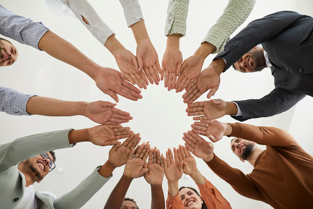 Group of happy diverse people joining hands in a circle.