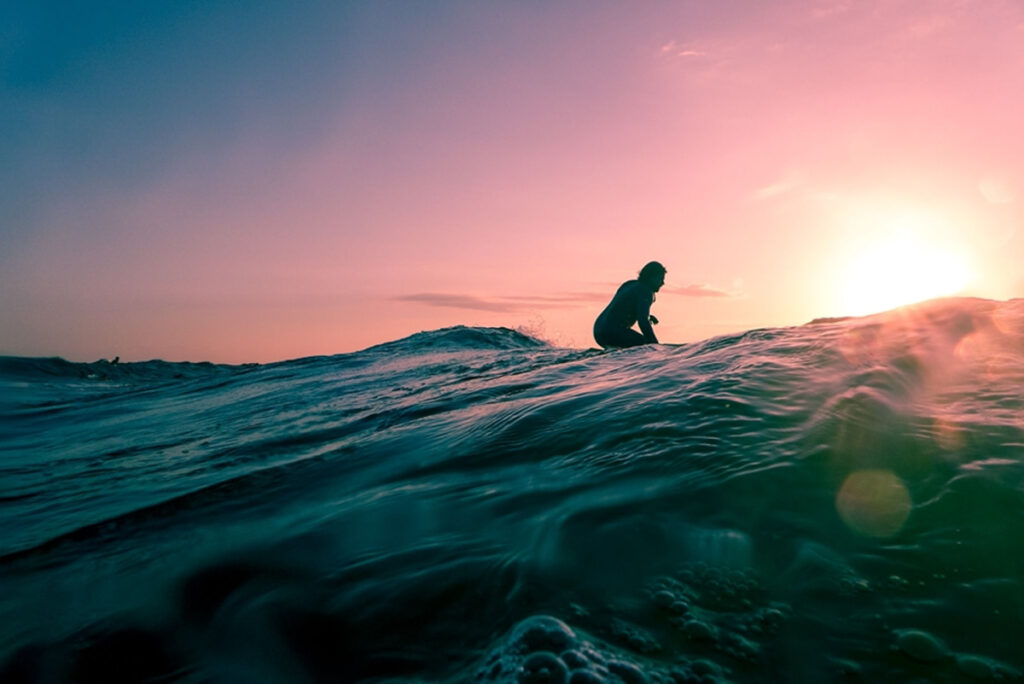 Man surfing on ocean water during golden hour, © Linus Nylund / Unspash