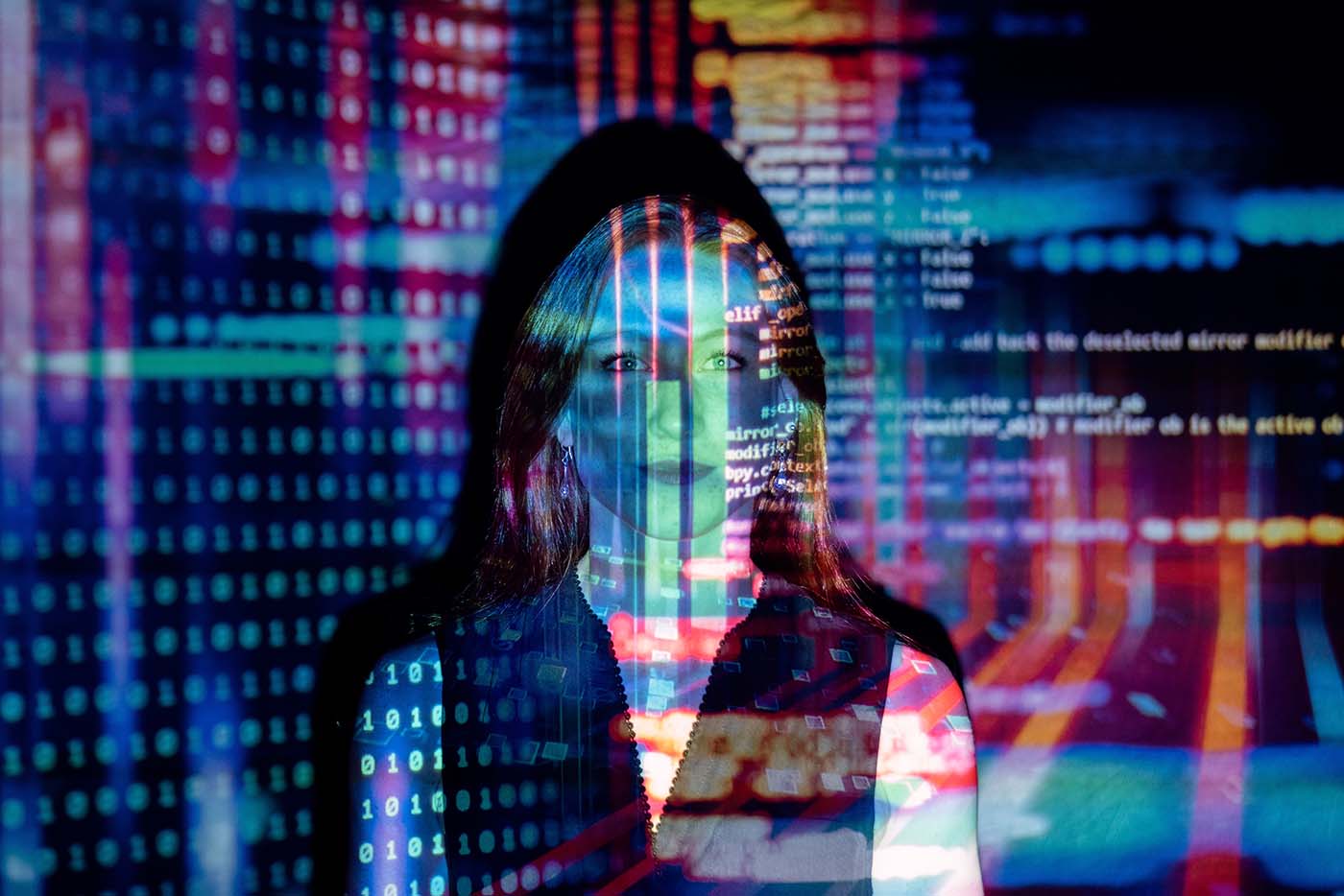 Women in tech and science. Photo of a woman with code projected on to her face.