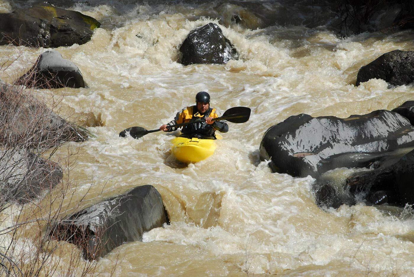 Man white water kayaking.