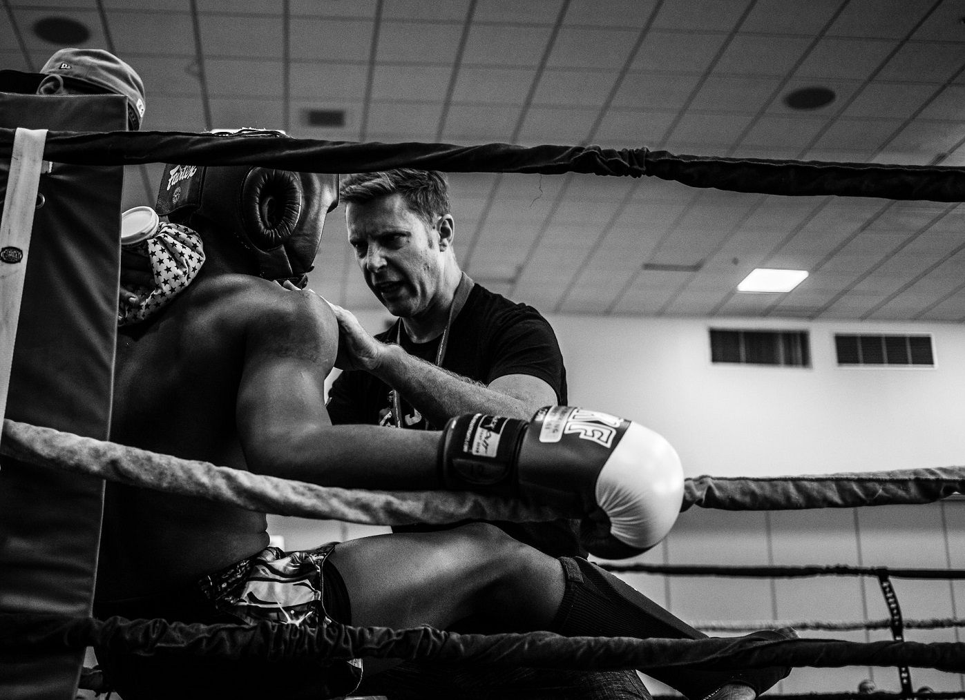 Photo of a boxing coaching talking to the boxer during a match