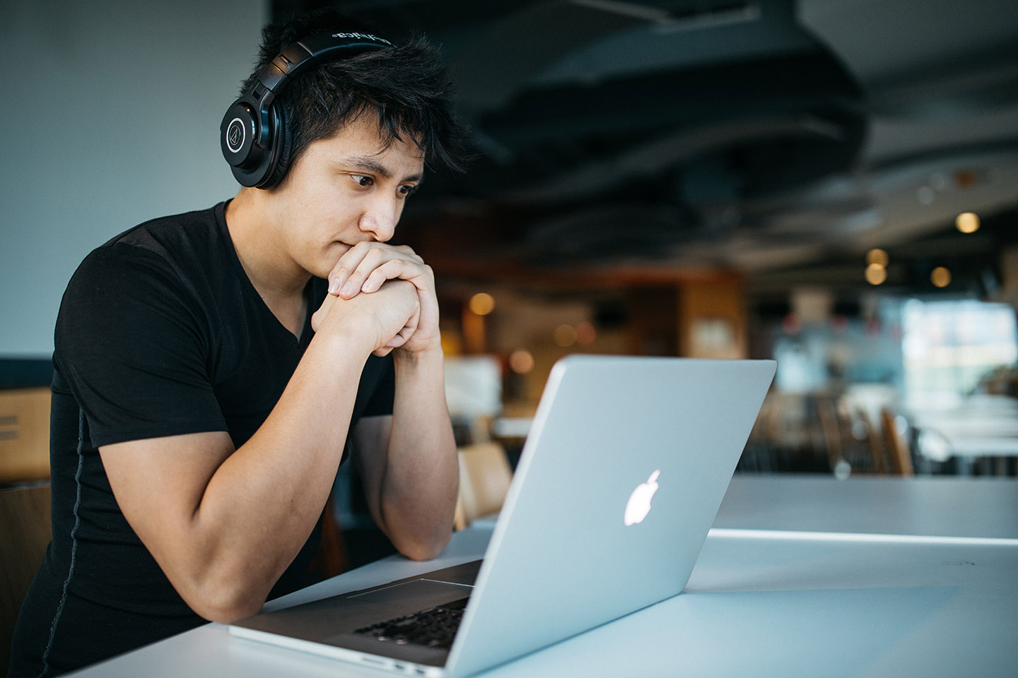 Man wearing headphones while sitting on chair in front of MacBook, Wes Hicks, Unsplash